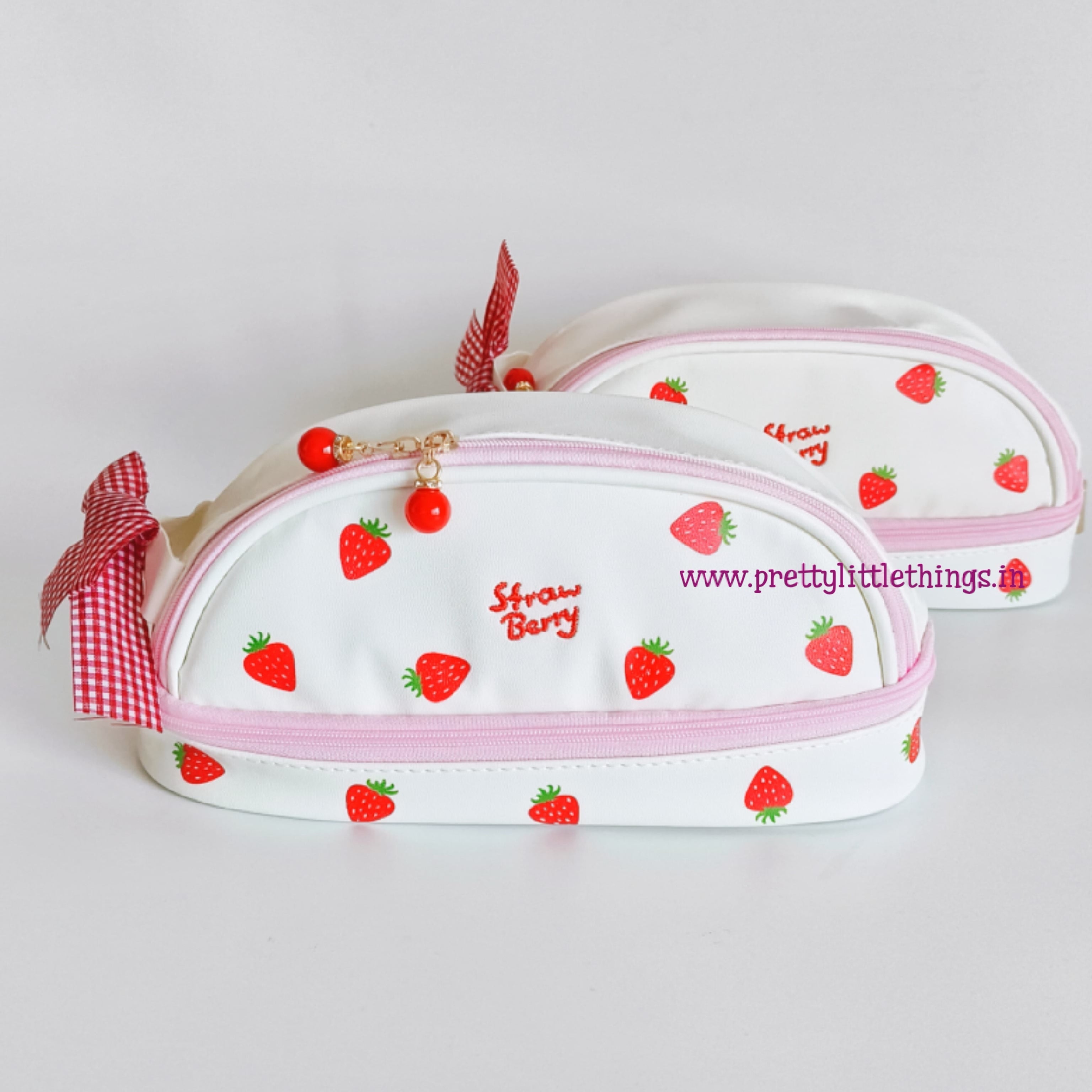 White pouch with strawberry pattern and pink ribbon on a white background