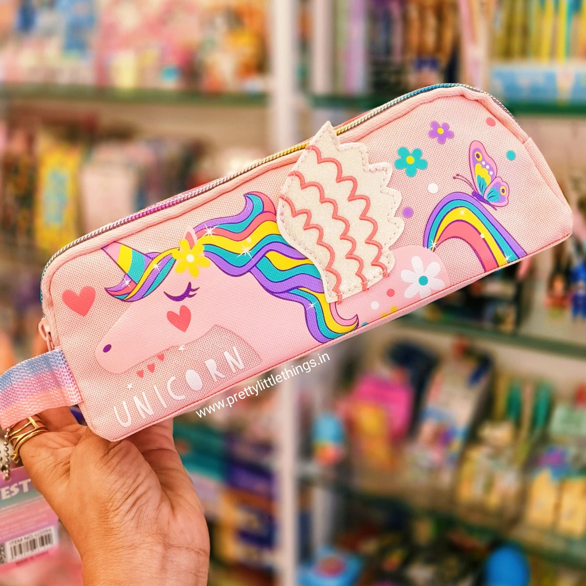 pink unicorn double zip pouch against the backdrop of a shop