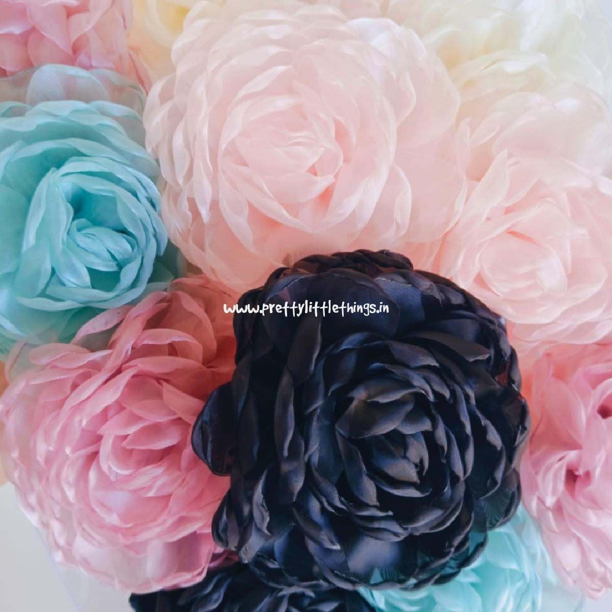 Colorful flower design scrunchies with pink, teal, nude pink and black flowers on a white background.
