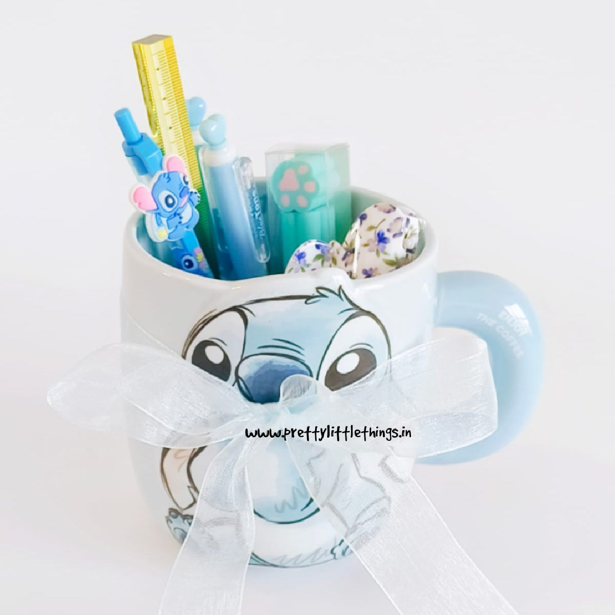 Mug with cartoon character design filled with stationery items on a white background