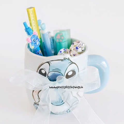 Mug with cartoon character design filled with stationery items on a white background