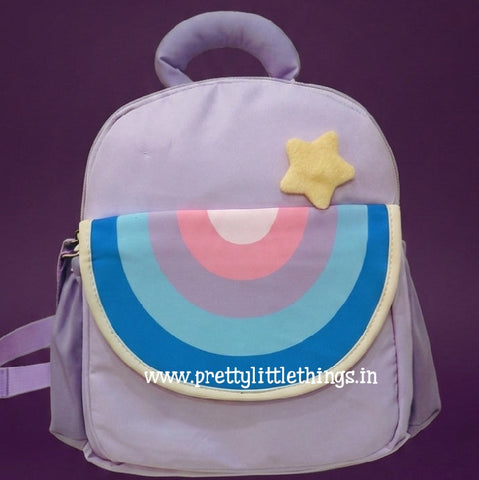 purple color backpack with rainbow type design on the front flap on a dark purple background